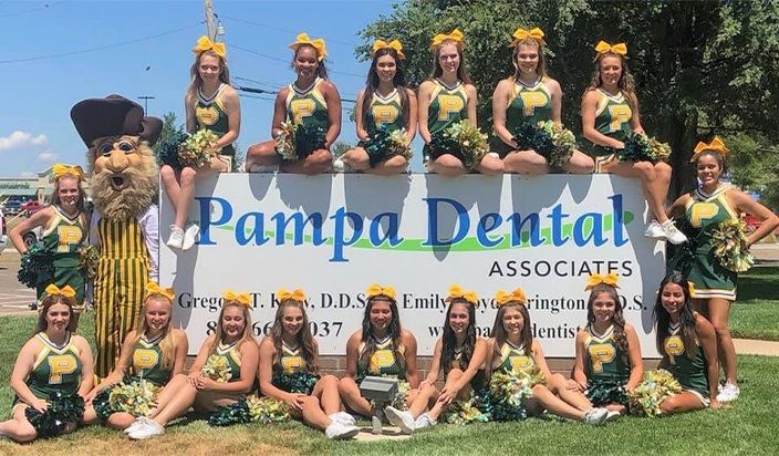 Cheerleaders around Pampa Dental Associates sign