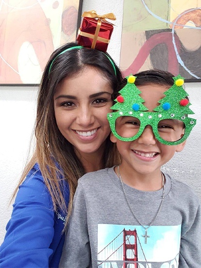 team member with boy wearing christmas tree glasses