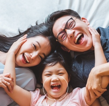 family of three smiling and laughing