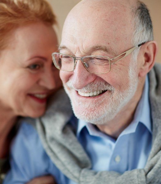 man smiling while wife lays head on shoulder