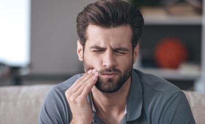 man with beard wincing in pain