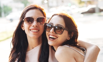 two sisters wearing sunglasses and smiling